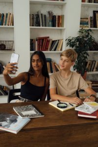 Man and Woman Taking Selfie Together While in the Library