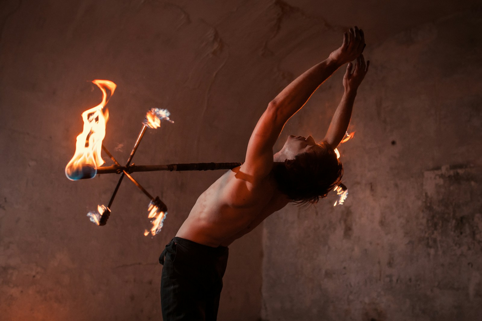 man in black pants holding fire